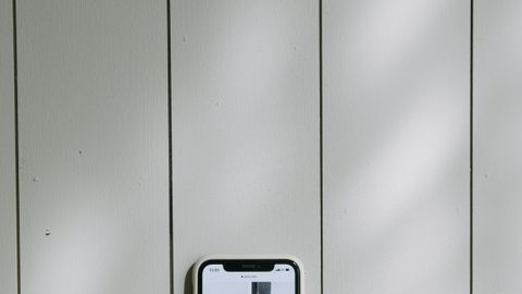 A smartphone displaying an online shopping app beside a credit card on a wooden surface, illustrating digital purchases.