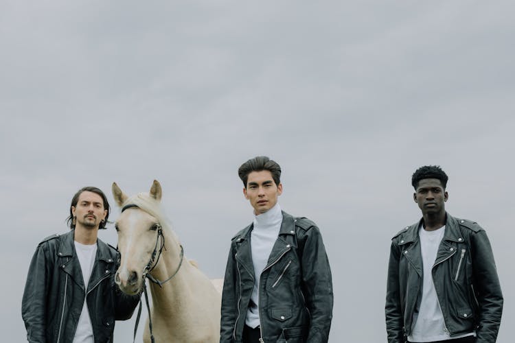 Men Standing With A White Horse