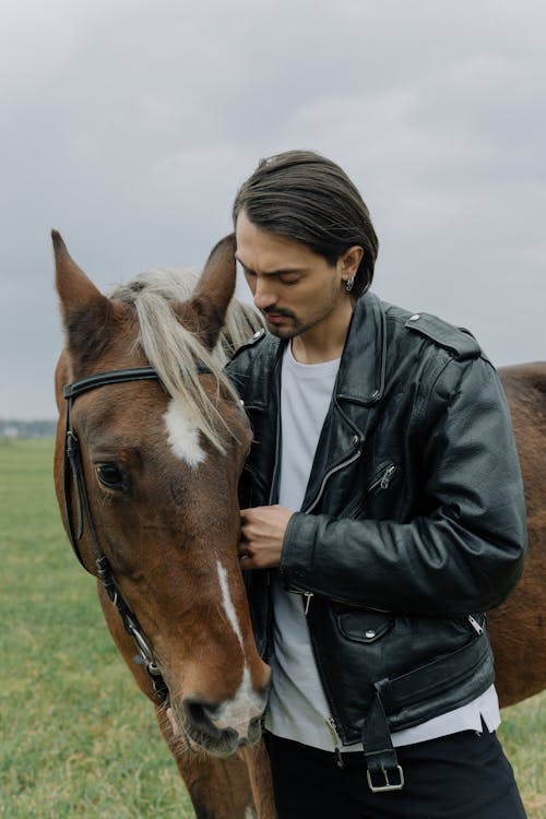 Man in Black Leather Jacket Beside a Brown Horse 