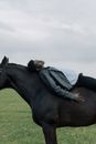 Man in Black Leather Jacket Lying on Brown Horse