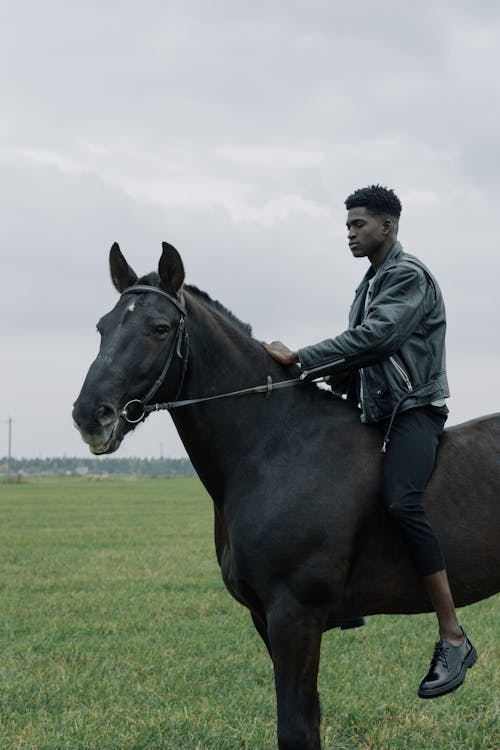 Man in a Black Leather Jacket Horseback Riding
