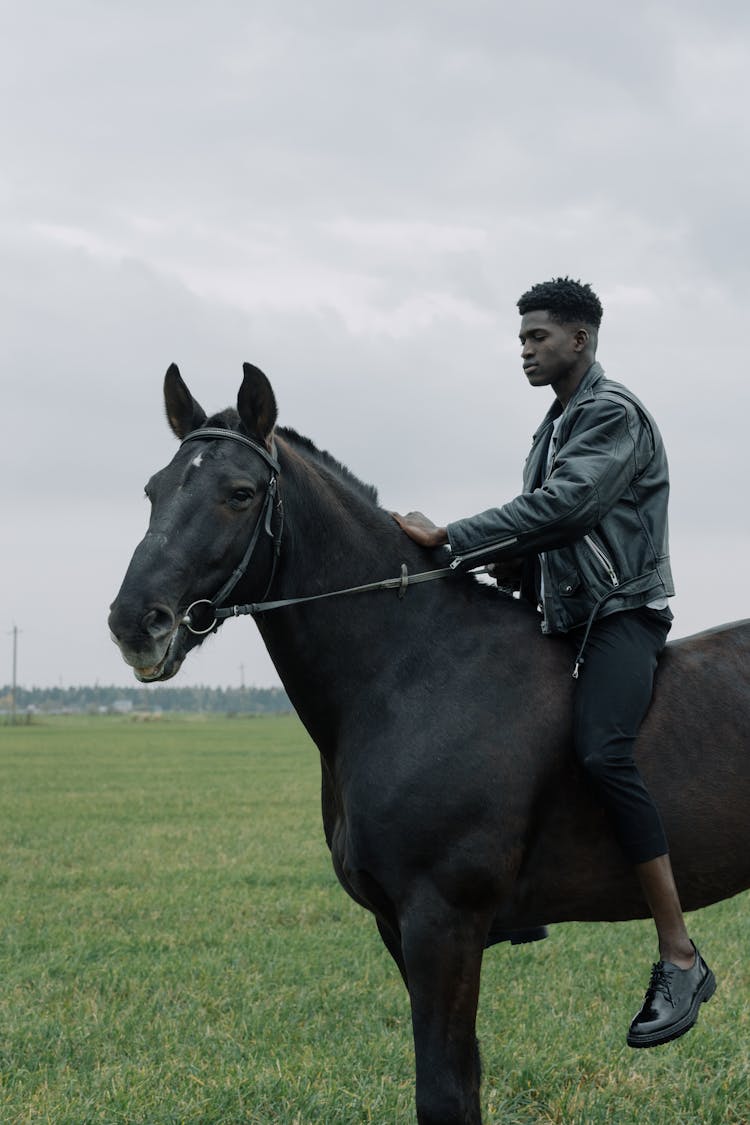 Man In A Black Leather Jacket Horseback Riding