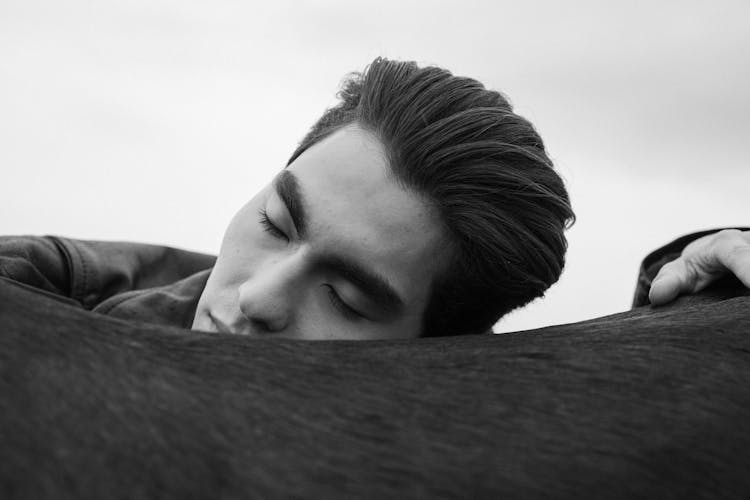 Grayscale Photo Of A Man Sleeping On A Couch