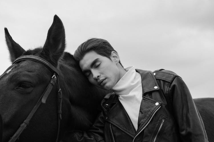 Man In A Jacket Leaning On A Horse