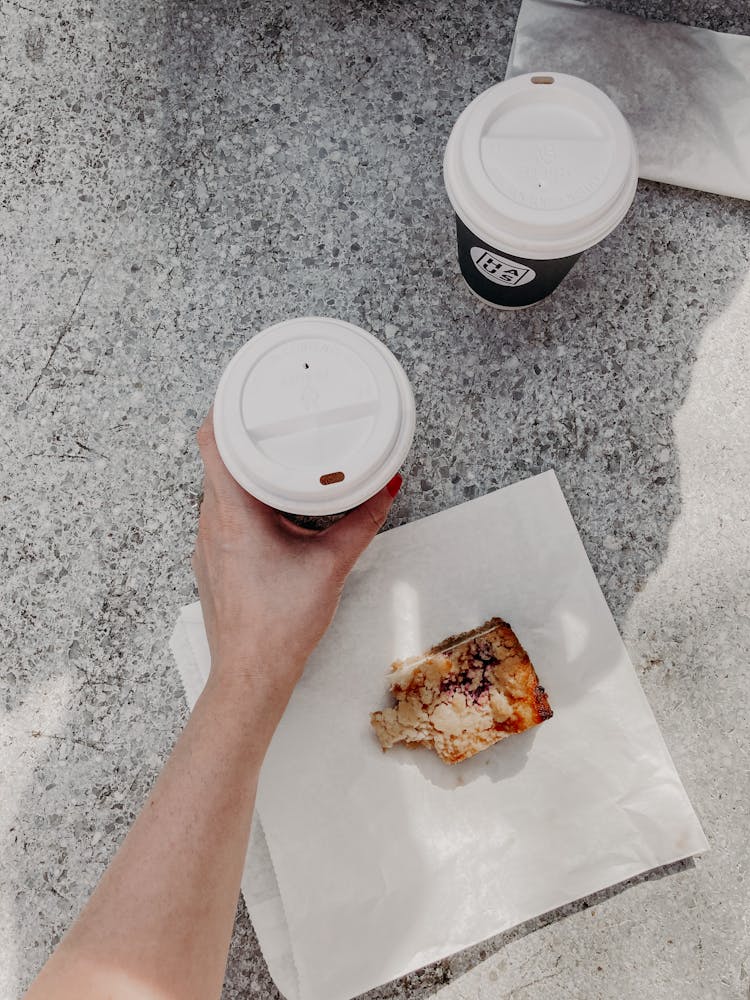 Unrecognizable Woman Drinking Coffee To Go And Eating Dessert On Street