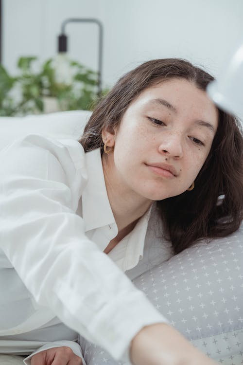 Free Smiling young woman resting in bed Stock Photo