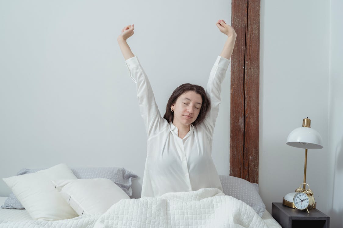 Sleepy woman waking up on bed in morning · Free Stock Photo