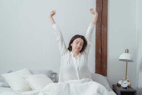 Sleepy woman waking up on bed in morning
