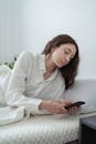 Young woman lying on bed with smartphone