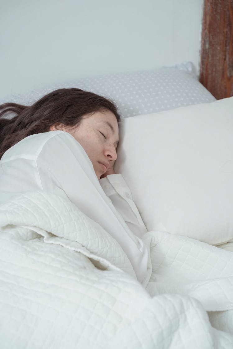 Young Woman Sleeping On White Bed