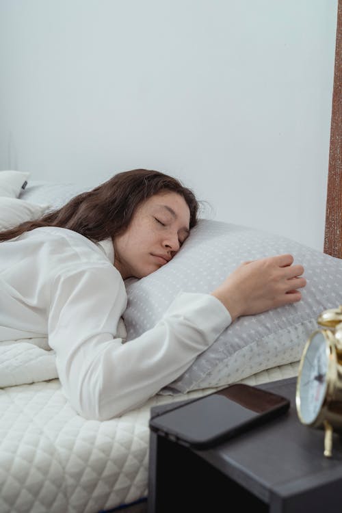 Free Calm young female sleeping peacefully on bed Stock Photo