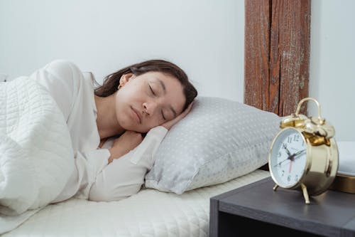 Calm woman sleeping on pillow in bedroom