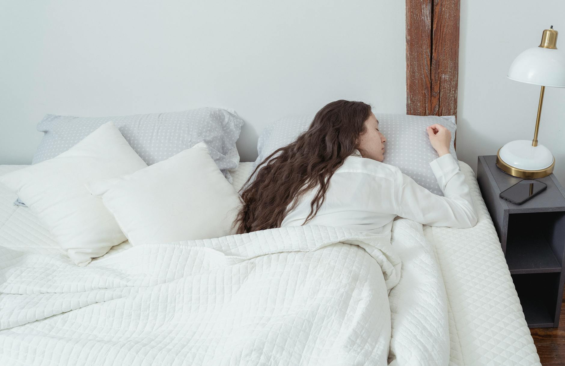 Woman sleeping in white bed