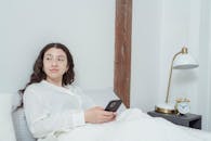 Woman Using a Cellphone on the Bed