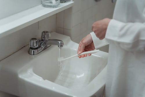 Woman Washing Her Toothbrush 