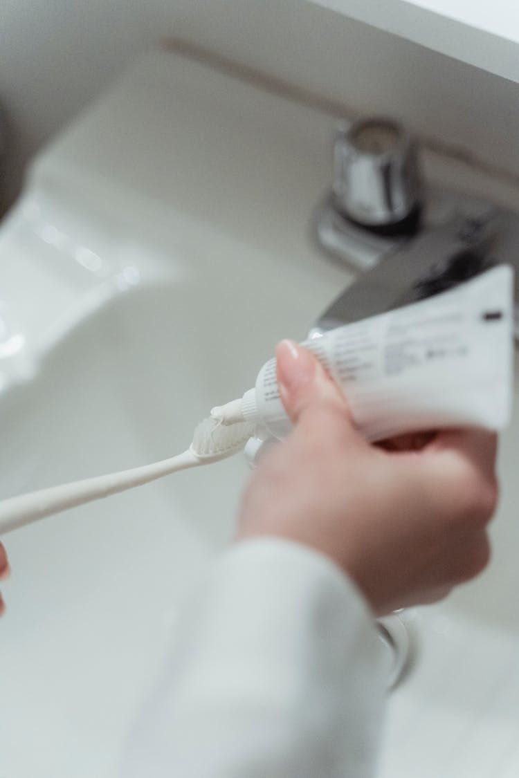 Person Holding Toothbrush And Toothpaste