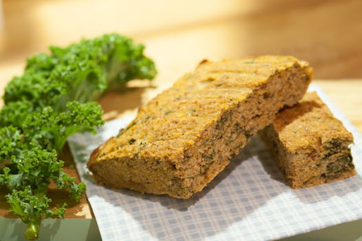 Close-up of freshly baked kale bread on a checkered napkin with fresh kale leaves.