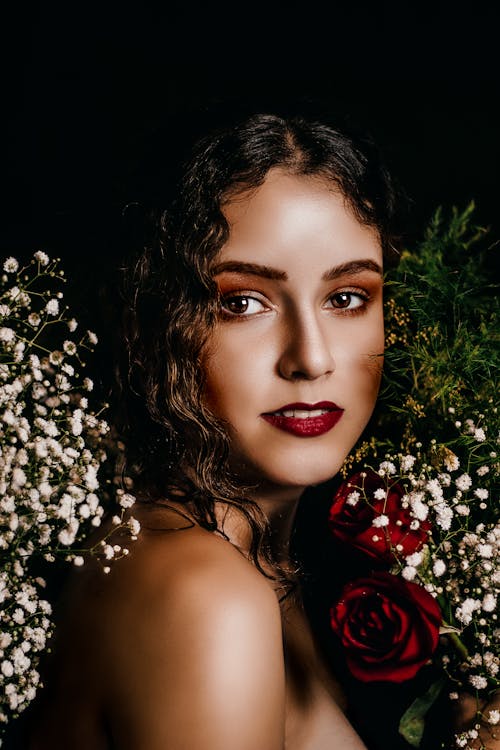 Free Portrait of a Woman With Red Lipstick Beside White Flowers  Stock Photo