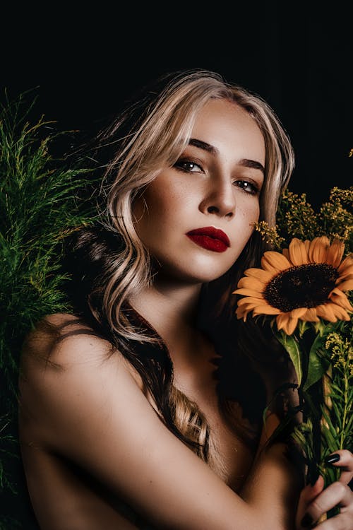 Free Beautiful Woman With Red Lipstick Holding A  Sunflower Stock Photo
