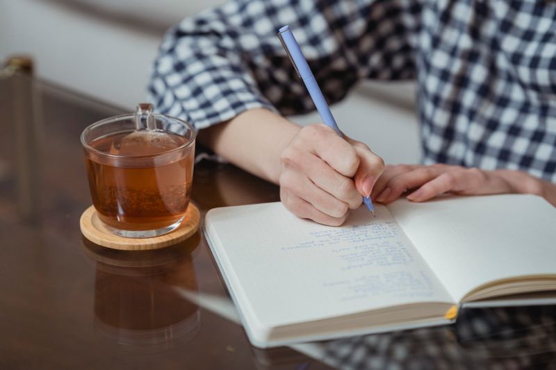 cup of herbal tea beside a dimmed lamp