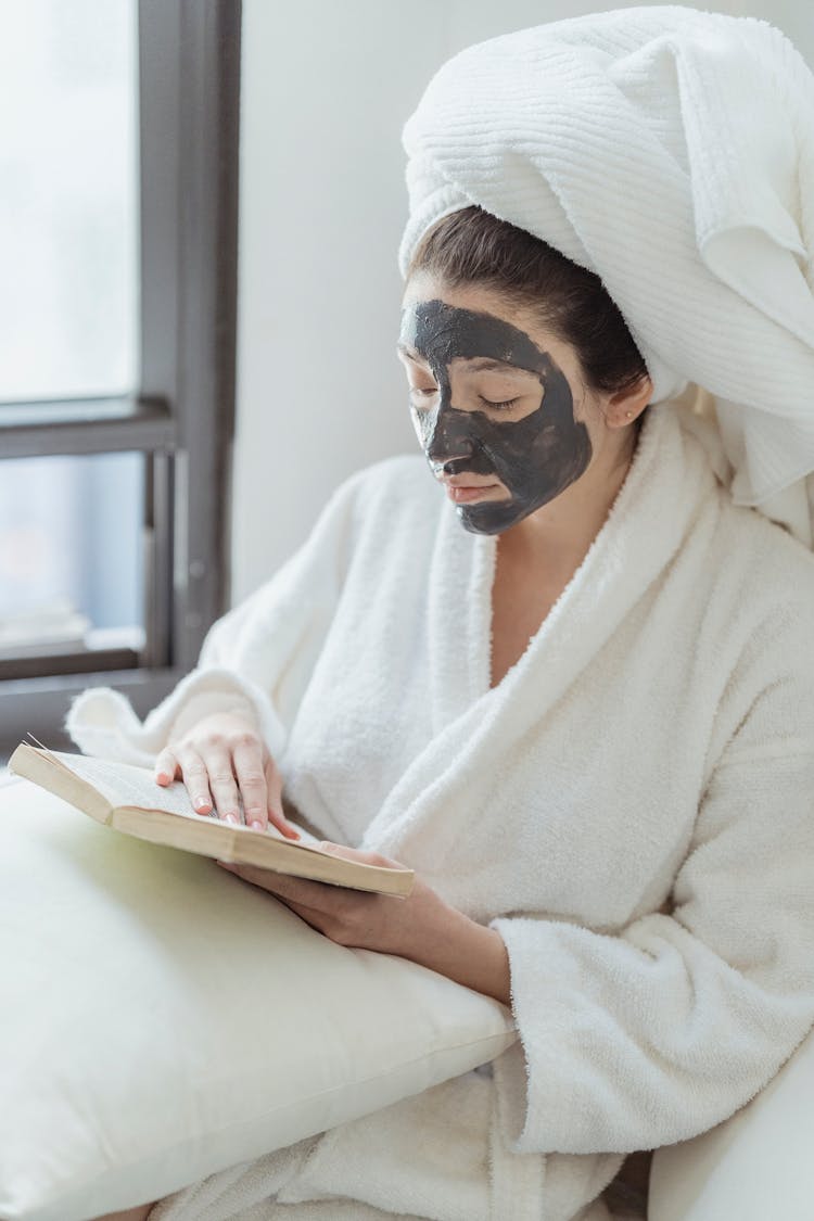 Woman Reading Book In Skin Care Face Mask