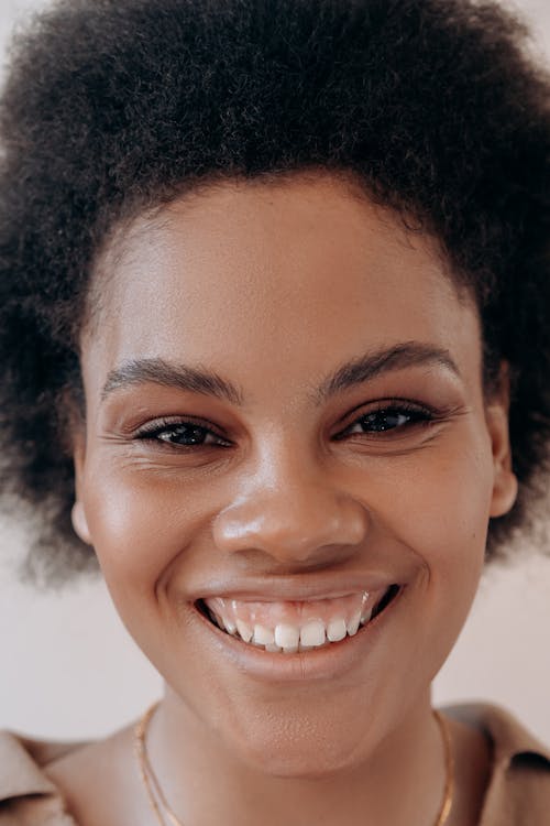 Close-Up Shot of an Afro-Haired Woman Smiling