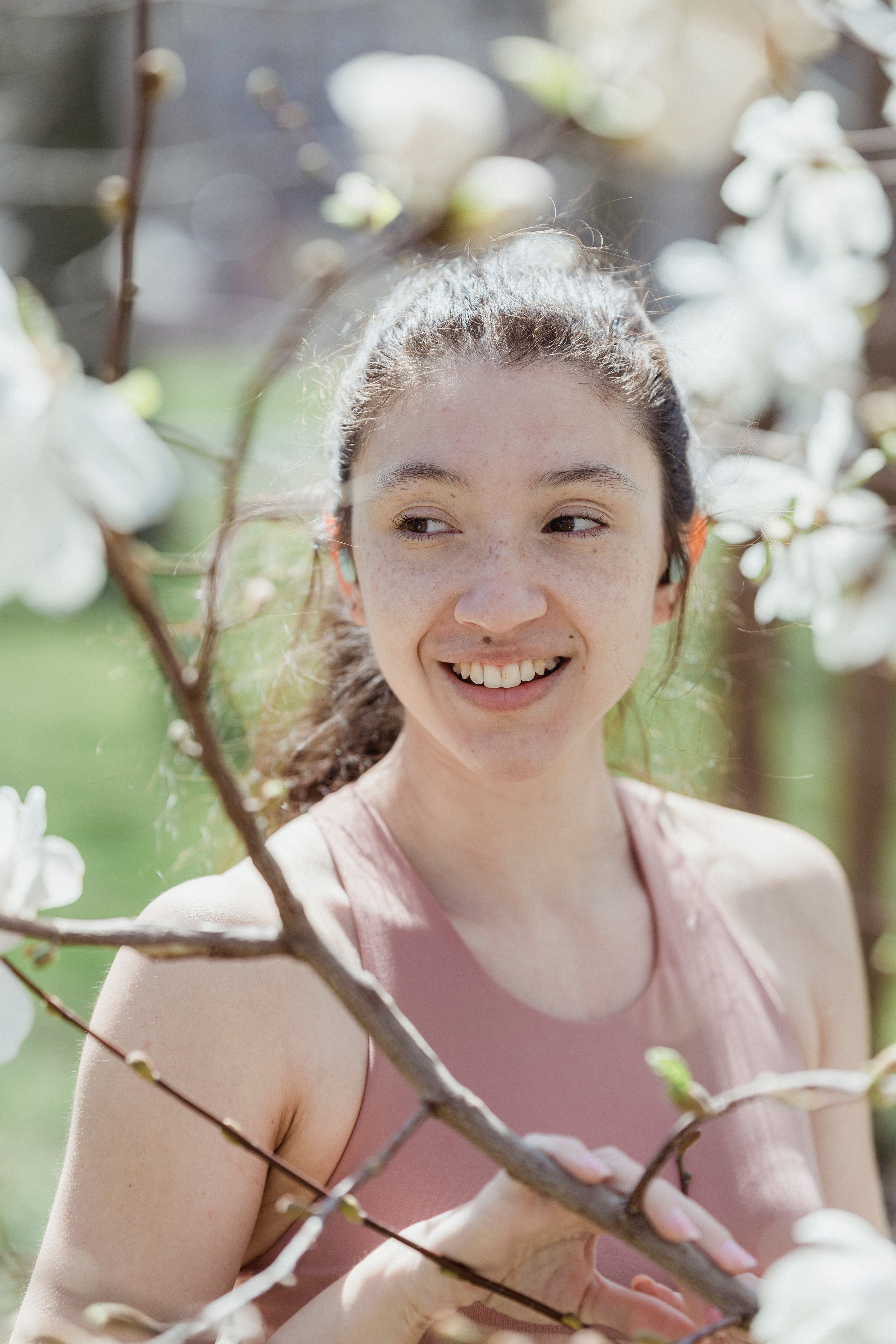 Smiling woman among blossoming magnolia branches — photo by Miriam Alonso on Pexels