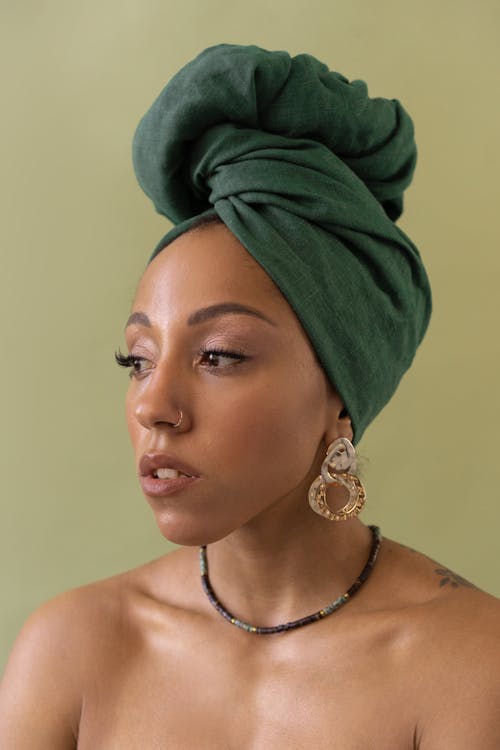 A Topless Woman in Green Turban Wearing Earring and Necklace