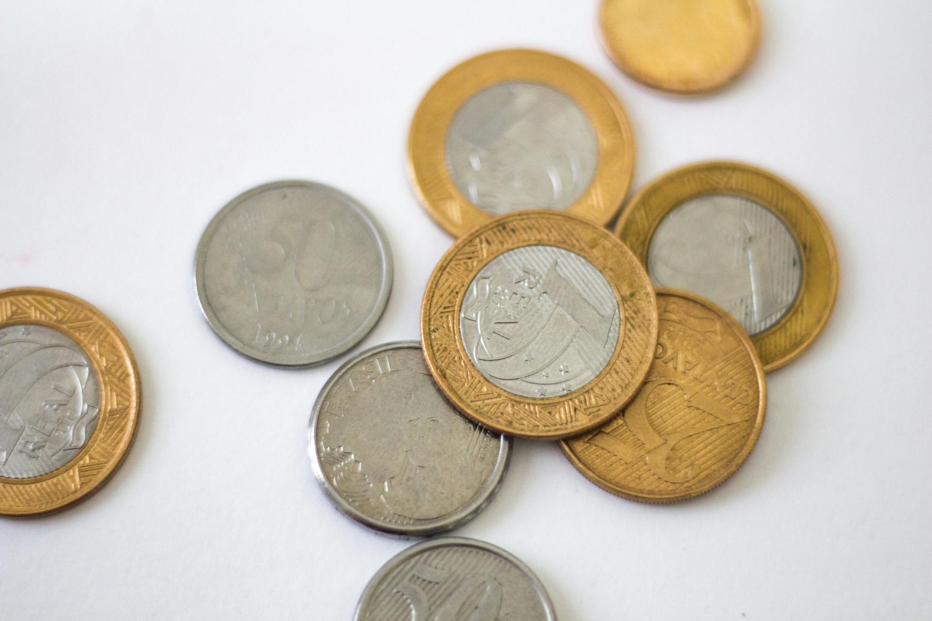 Detailed close-up of Brazilian coins displaying various denominations on a clean white surface.