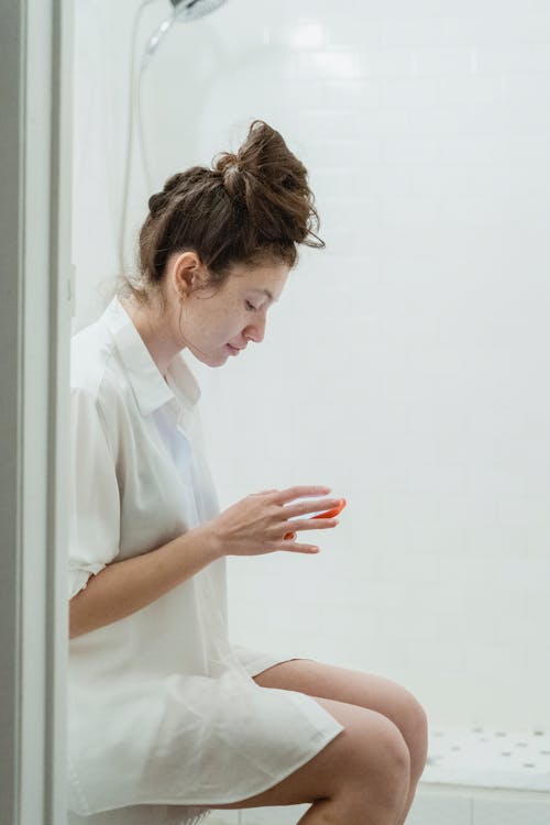 Free A Woman Using Her Cellphone in the Comfort Room Stock Photo