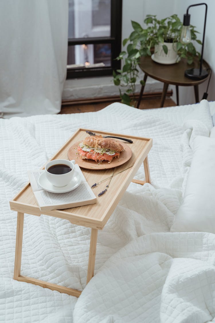 Breakfast With Coffee On A Portable Table On White Bed Linen