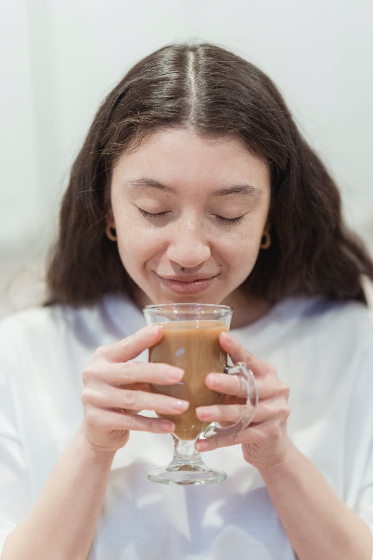 Happy Woman Smelling Coffee In Glass