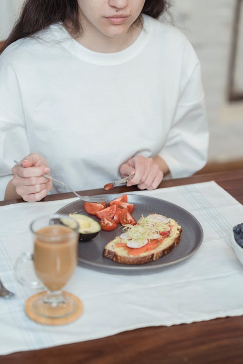 Woman Eating Sandwich and Fruits