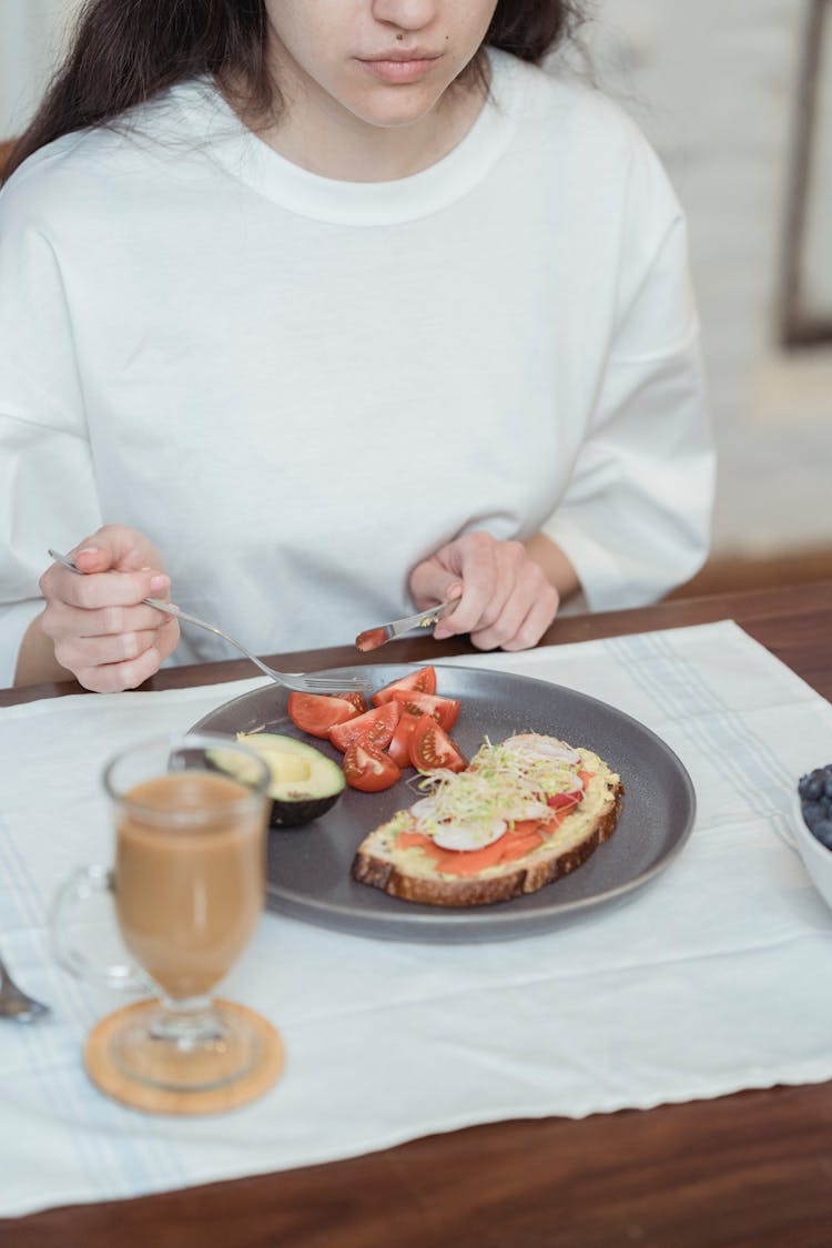 Woman Eating Sandwich And Fruits