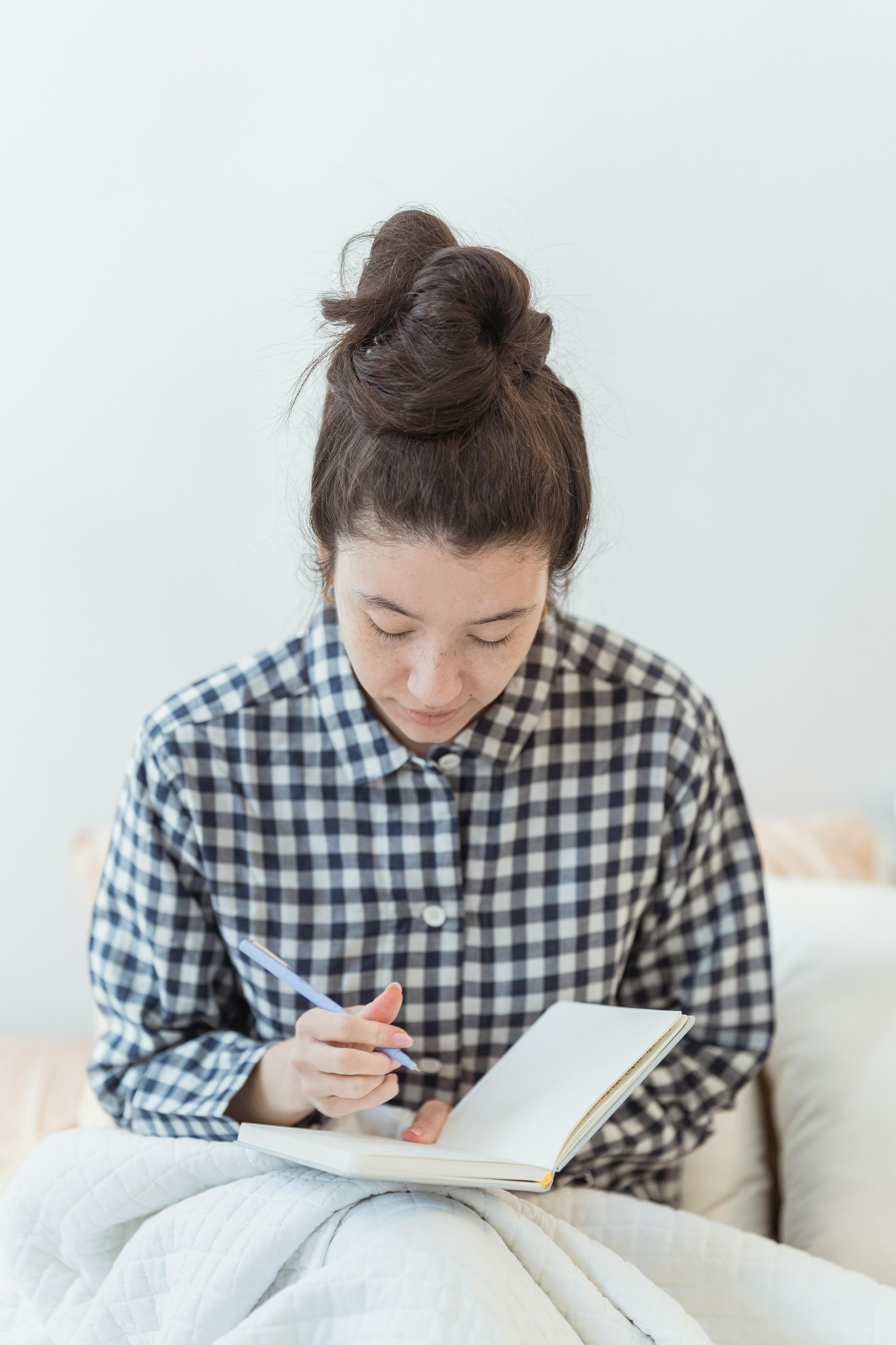 woman in checked shirt journaling