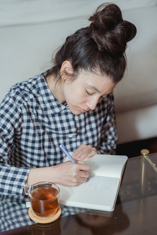 A Woman Writing on the Notebook