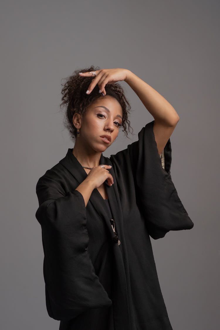 An Afro-Haired Woman In Black Robe Posing