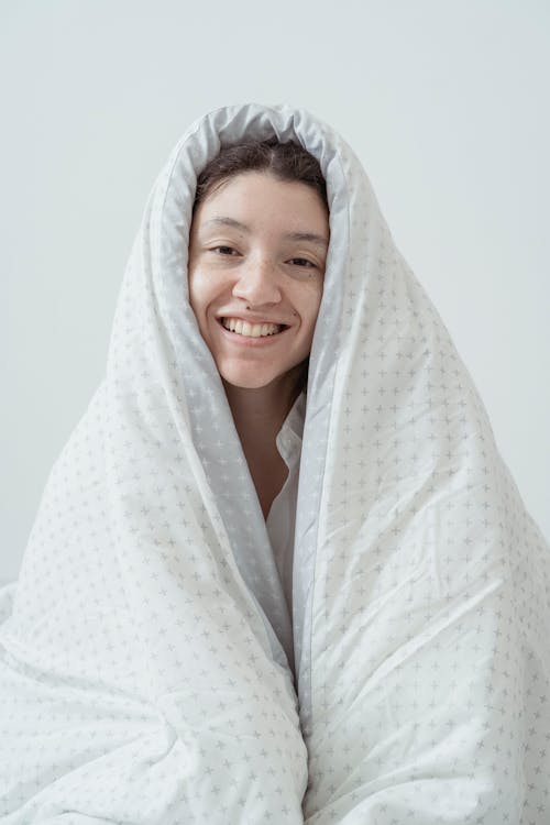 Free A Woman Covering Herself with White Blanket Stock Photo