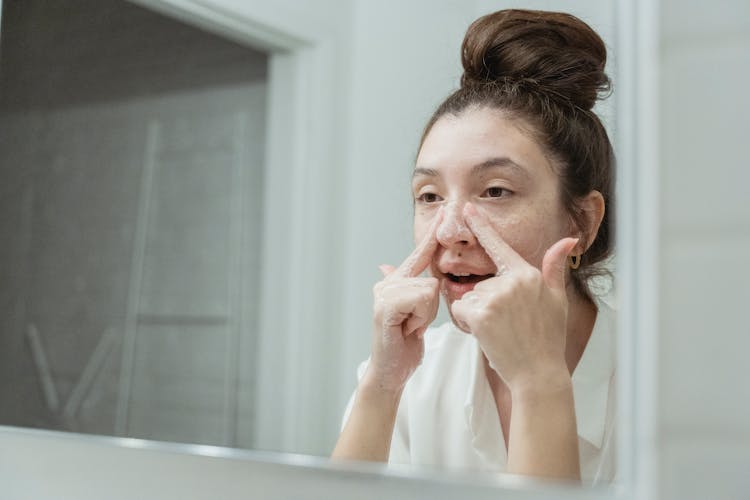 Young Woman Washing Her Face In The Bathroom 