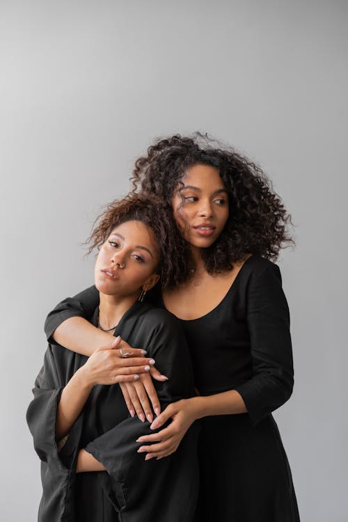 Free Two Afro-Haired Women in Black Robes Hugging Stock Photo