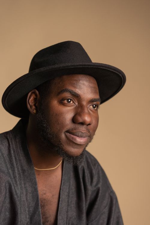 Free Studio portrait of a bearded man wearing a fedora hat and smiling warmly. Stock Photo