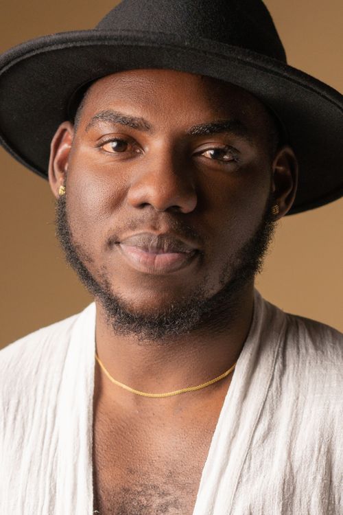 Free Close-up portrait of a smiling man wearing a black hat and white shirt, set against a warm background. Stock Photo