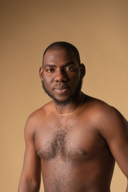 Free Studio portrait of a topless black man with a beard, exuding confidence on a neutral background. Stock Photo