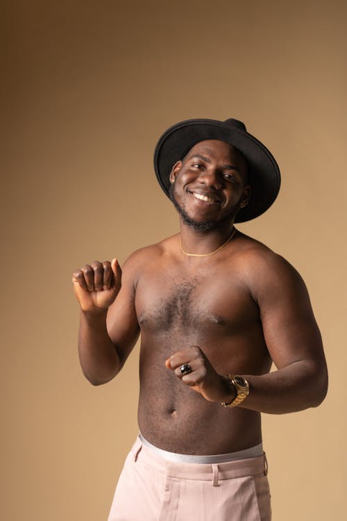 Free A Shirtless Man Smiling while Wearing a Hat Stock Photo