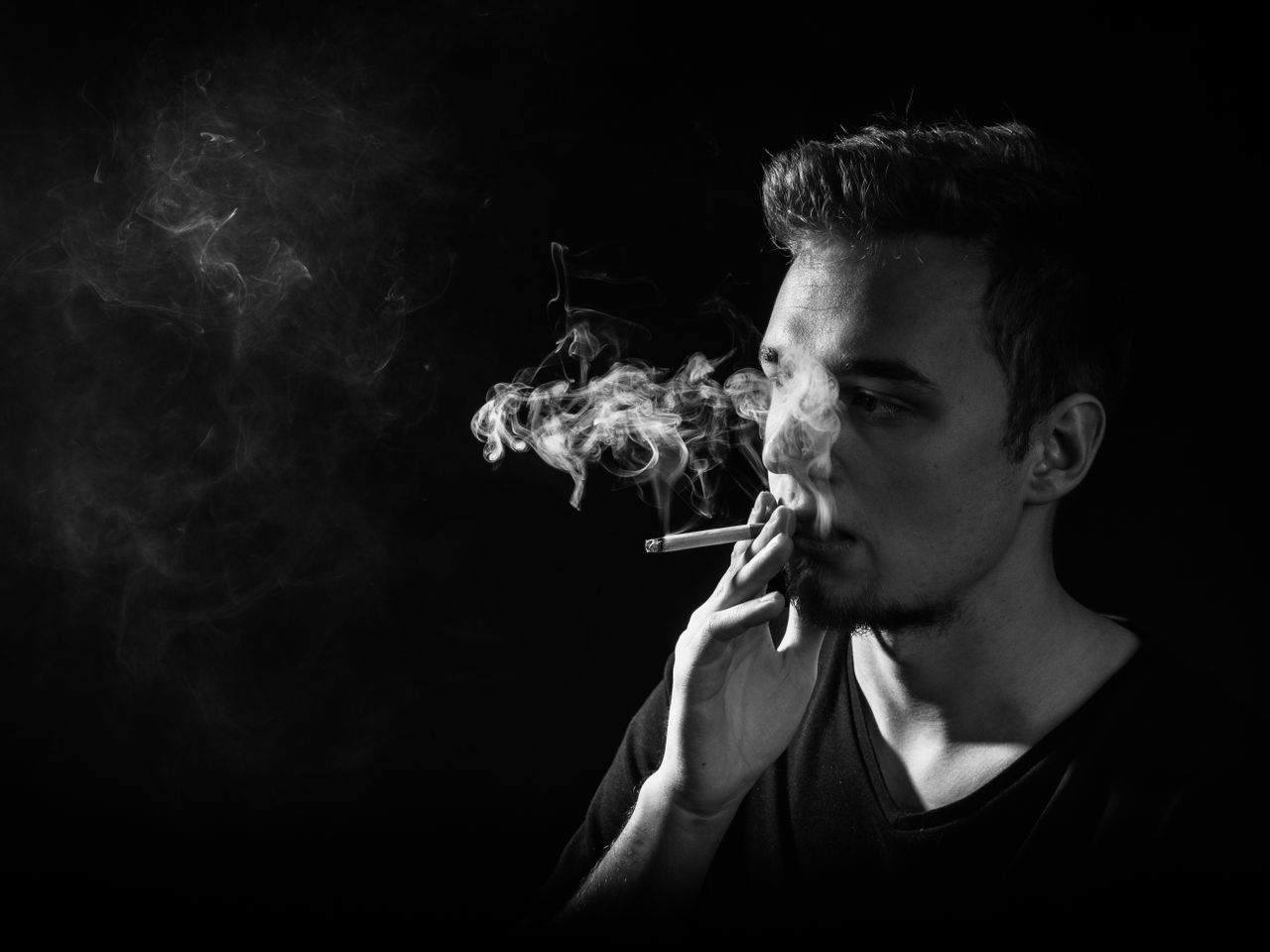 black and white portrait of a man smoking with smoke swirling around i