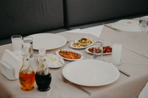 Free From above of table with tablecloth served with dishware and delicious appetizers and beverages in restaurant Stock Photo