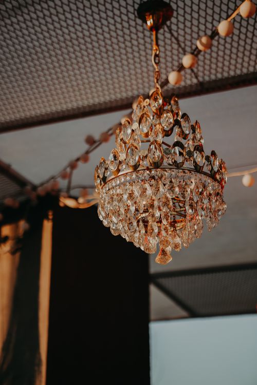 Free A classic crystal chandelier hanging with warm ambient lighting, perfect for indoor decor. Stock Photo