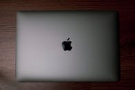 A Silver Macbook on a Wooden Surface