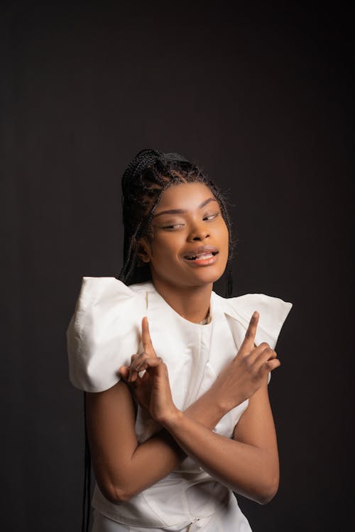 Woman in White Top with Braided Hair on Black Background