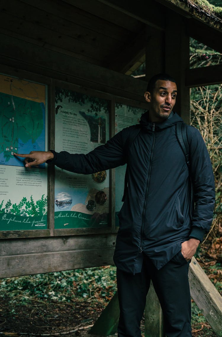 Man In Hiking Gear Pointing At A Map